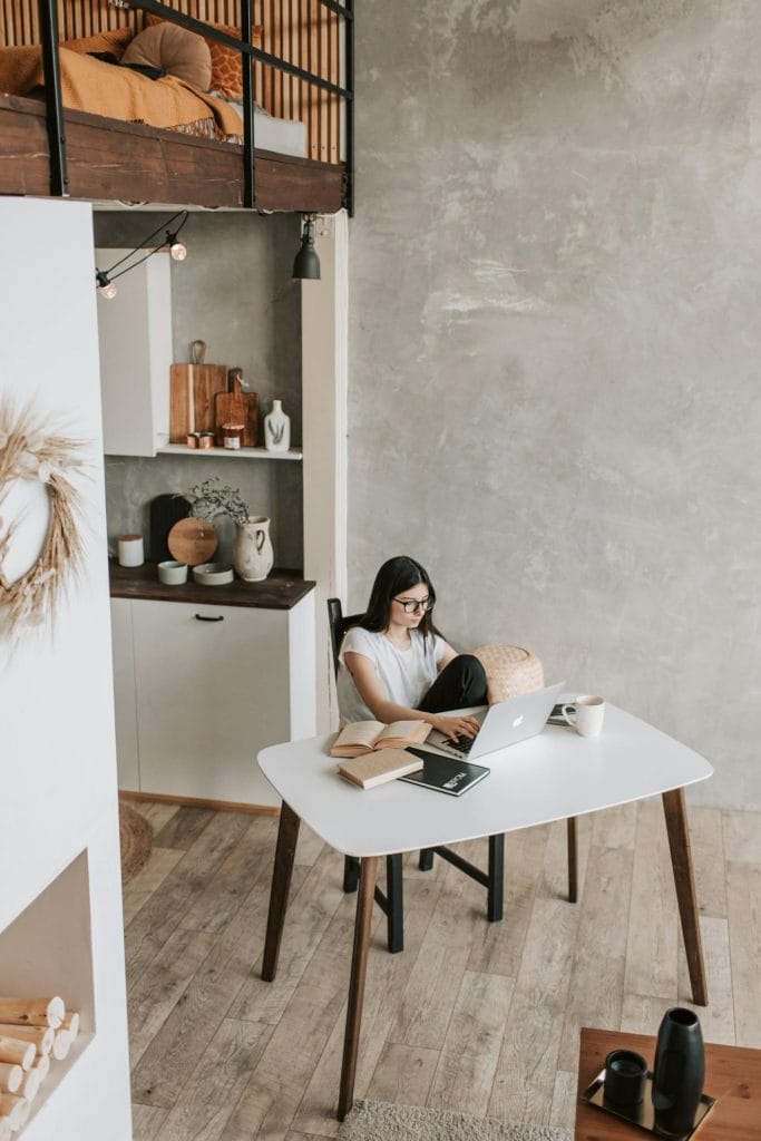 a woman sitting at a table with a laptop